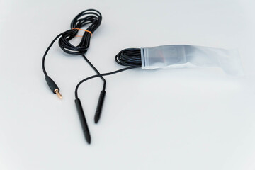Isolated Audio Cable with Double Plug Connector Partially Stored in Plastic Packaging on White Surface