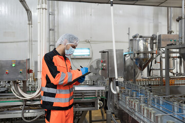 Fototapeta premium Canned fish factory, seafood manufacturing and food processing. Conveyor belt and production engineer. Plant engineer inspecting quality, repairing, maintenance of seafood processing conveyor belts