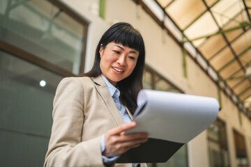 Fototapeta premium japanese businesswoman read information from clipboard at work place