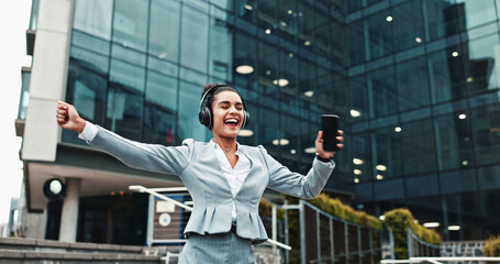 Woman, phone and dancing with headphones in city for music, work break and streaming audio. Business, happy person and energy with singing for sound subscription, celebration and radio app outdoor