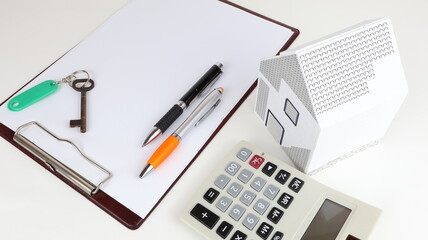 Close up of house model with office stationery accessories isolated on white background