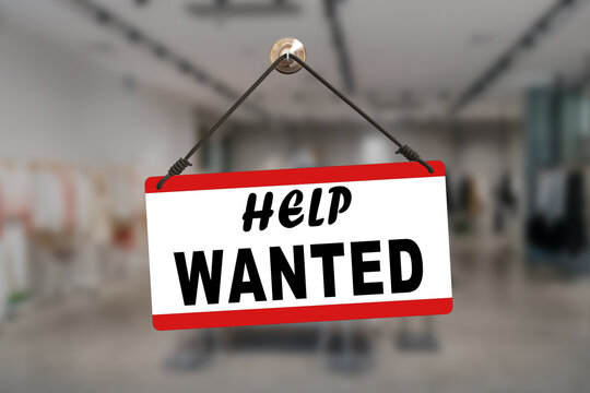 Blue and red sign hanging at the glass door of a shop saying: "Help wanted".