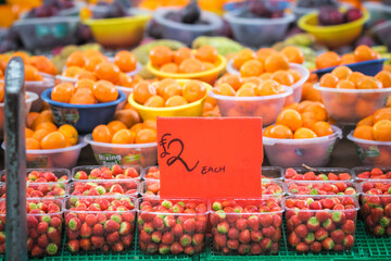 Strawberries and oranges displayed at a fruit stand in Walthamstow Market in London, England