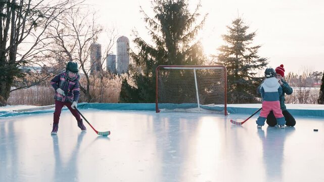 Family playing hockey on the outdoor rink
