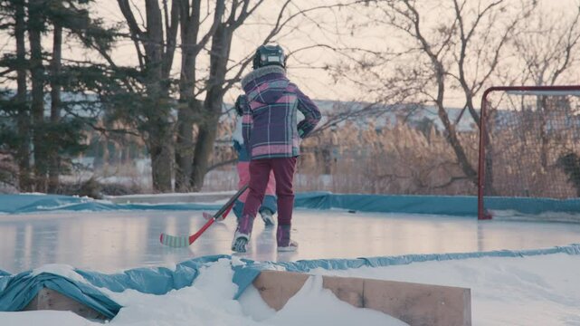 Kids playing hockey outdoors on the ice