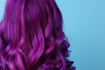 Naklejka premium Beautiful woman with bright purple hair on light blue background, back view