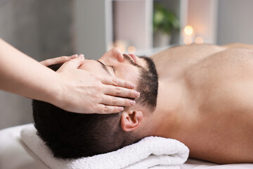 Man receiving relaxing massage in spa salon