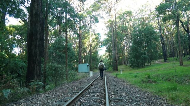 A traveling swagman walks to an abandoned railway station in the Australian bush.