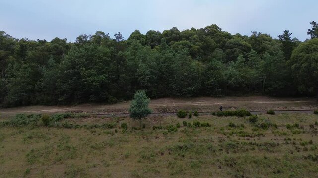 Aerial shot of a traveling swagman walking a historic railway line in Australia.