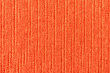 Fototapeta premium Close-up of orange fabric with a pattern of vertical lines. Soft, warm and elegant textile background.