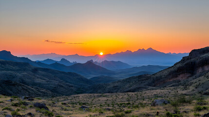 Obraz premium Sunset Over Mountain Range Revealing Silhouette Against Orange Sky Above Valley With Arid Terrain