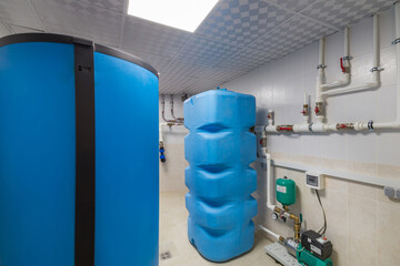 Boiler room with autonomous heating system. Blue tanks, pipes with valves, sensors and pressure...