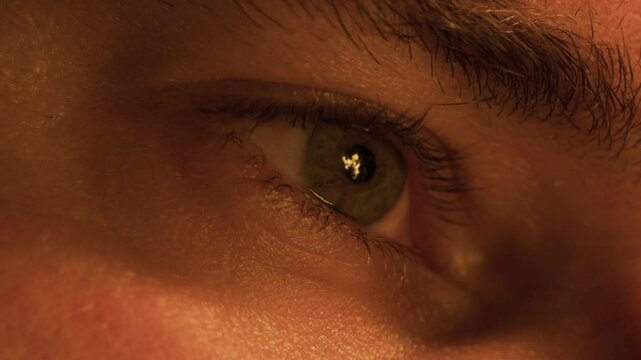 Macro close-up the flame of a fire is reflected in the human male eye and mydriatic pupil