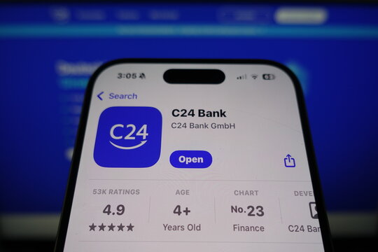 Kiel, SH, Germany March 27 2025: C24 Bank app by C24 Bank GmbH is available for download on smartphone screen with company's website displayed in the background