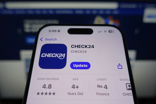 Kiel, SH, Germany March 27 2025: CHECK24 app showcased in App Store on smartphone screen while company website is displayed on a nearby monitor