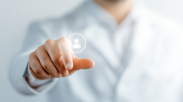 A person wearing a light-colored shirt is pressing a digital button displaying a user icon with their index finger.