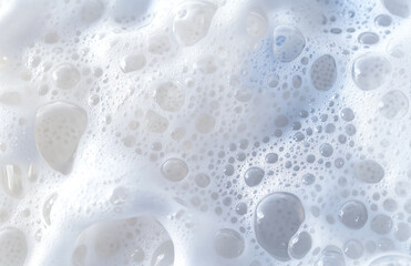 A close up view of white foam with many bubbles of varying sizes filling the entire frame uniformly