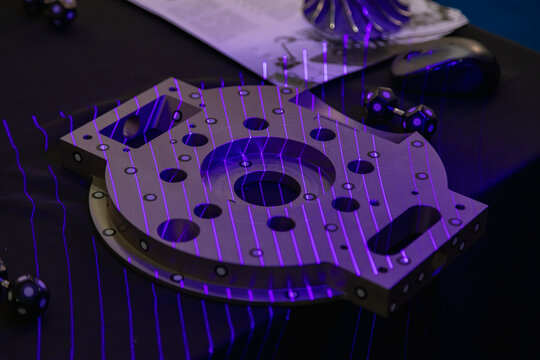 Purple laser lines scanning a mechanical component, enhancing precision in reverse engineering and quality control processes