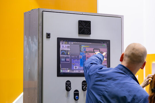 Two engineers are checking parameters on a control panel with a monitoring system, ensuring smooth operation and preventing potential issues