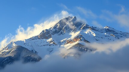 Fototapeta premium A majestic mountain peak covered in snow, standing tall above the clouds
