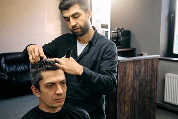 A skilled hairdresser is meticulously cutting a client's hair in a contemporary barbershop. The atmosphere is relaxed with soft lighting and a comfortable seating area, creating a welcoming vibe