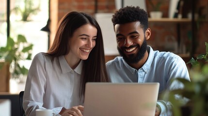 Productive collaboration. Smiling friendly business team two young diverse multiethnic office employees work on project together using notebook pc at workplace engaged in job discuss successful ideas