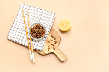 Glass bowl with fried insects and lemon on beige background