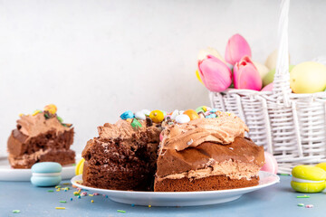 Easter Egg Nest Chocolate Cake. Sweet Easter cake with crushed chocolate eggs, traditional holiday baking recipe idea, on festive decorated table copy space