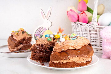 Easter Egg Nest Chocolate Cake. Sweet Easter cake with crushed chocolate eggs, traditional holiday baking recipe idea, on festive decorated table copy space