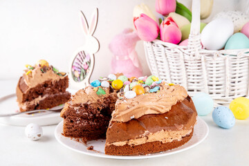 Easter Egg Nest Chocolate Cake. Sweet Easter cake with crushed chocolate eggs, traditional holiday baking recipe idea, on festive decorated table copy space