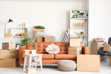 Sofa with table and cardboard boxes in living room on moving day