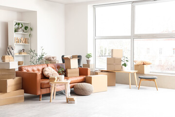 Sofa with table and cardboard boxes in living room on moving day