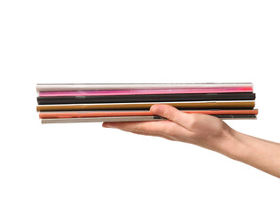 Female hand with stack of many different magazines isolated on white background