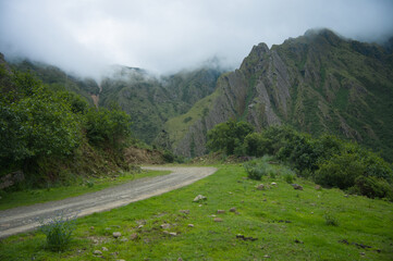 A winding road leading to the village is adorned with green hills.