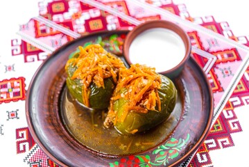 Traditional Ukrainian Stuffed Peppers with Carrots and Sour Cream on Embroidered Tablecloth
