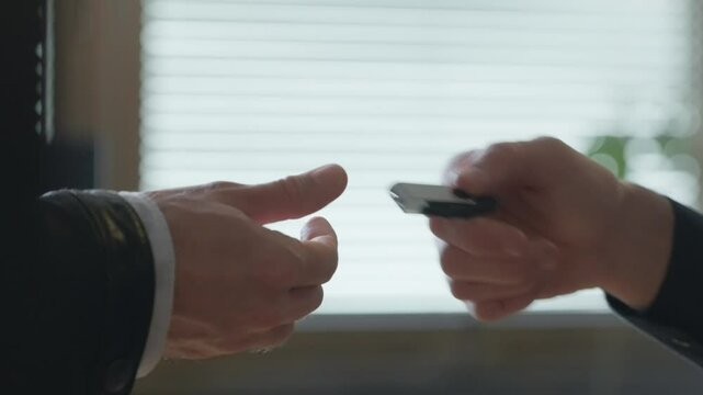 Man discreetly hands over USB stick to another, Close-up of hands. Evoking sense of confidentiality, secrecy, and data exchange. Suggesting espionage, cyber security, classified information transfer.