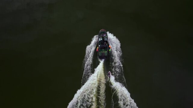 Wake surf surfing water sports MB boat wave family activity Lake Crowley Mammoth Mountain Lakes California aerial drone golden still calm water morning sunny fall autumn Birds Eye follow motion