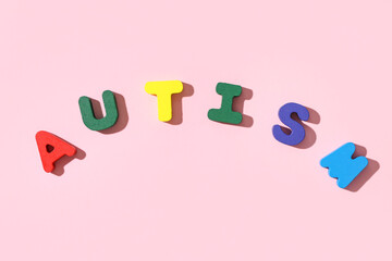 Word AUTISM made from colorful letters on pink background