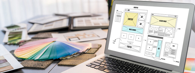 Obraz premium Interior designer workspace table and architecture software on laptop screen with mood board materials and colorful swatch color for color selection. Modern interior design office. Insight
