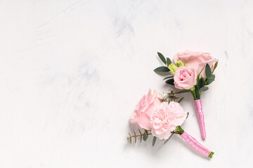 Beautiful boutonnieres on light background