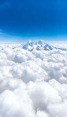 Snowy mountain peaks emerge above a vast expanse of fluffy white clouds under a vibrant blue sky
