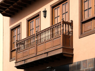 Traditional wooden balcony and windows on a historic colonial building facade