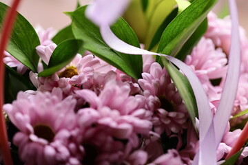 A close-up view of a bouquet of colorful flowers arranged in a wicker basket.