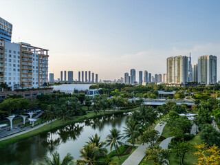 modern green urban park with green lawns and palm trees in downtown of big city with skyscrapers and contemporary architecture, sala luxury residential district, Ho Chi Minh, Vietnam