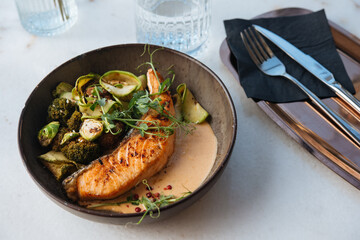 Grilled salmon with brussels sprouts and broccoli served for a dinner in a restaurant.
