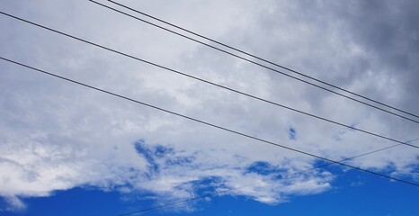 cloudy sky with black clouds indicating rain and stretched power lines
