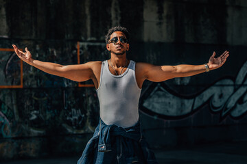 portrait of a young man on the street with his arms open