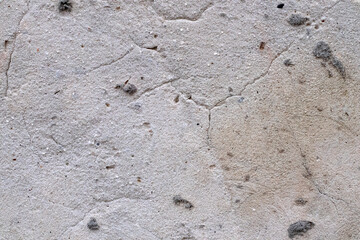 The texture of a very old concrete wall with cracks