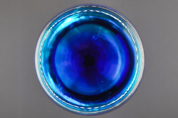 Colored water dropping into a wine glass filled with water.