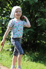 little girl is walking in the village. child is hopping on the road. countryside scene.